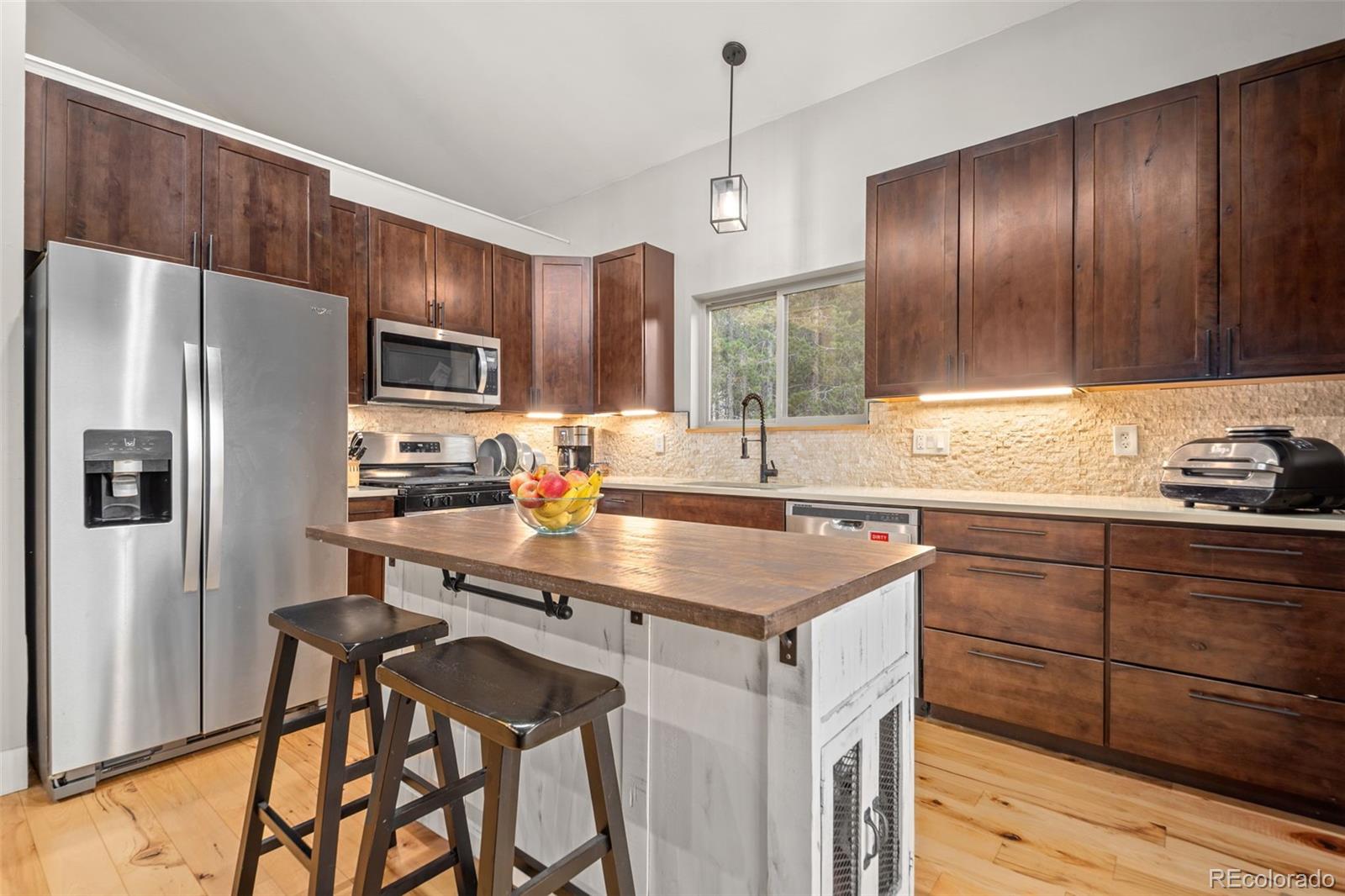 258 Upper Forest Road Idaho Springs, CO 80452 - Photo 17 of 48 a kitchen with stainless steel appliances a sink a stove a refrigerator cabinets and wooden floor