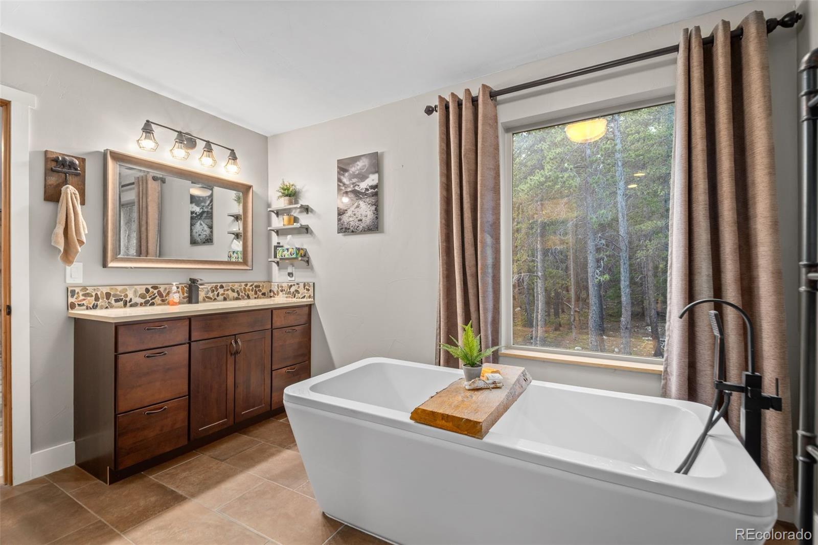 258 Upper Forest Road Idaho Springs, CO 80452 - Photo 22 of 48 a bath tub sitting in a bathroom next to a window