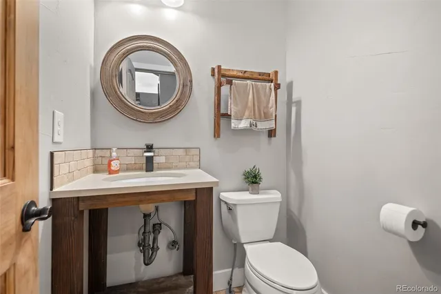 a bathroom with a toilet a sink and a mirror