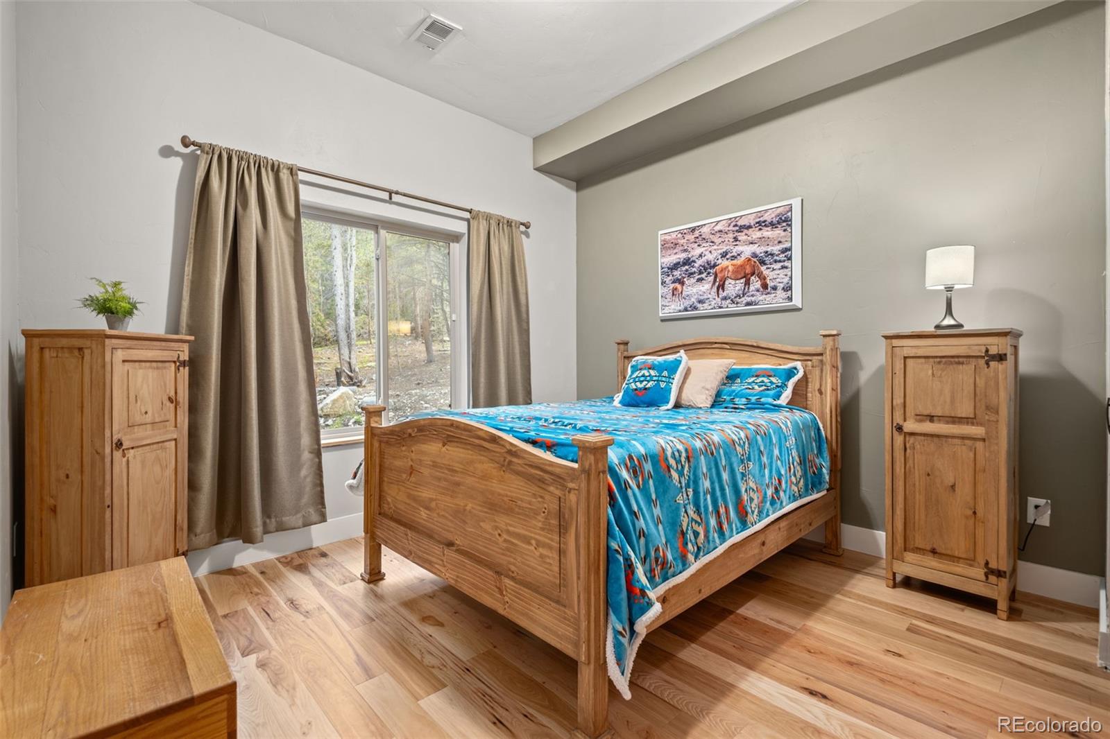 258 Upper Forest Road Idaho Springs, CO 80452 - Photo 7 of 48 a bedroom with a bed and wooden floor