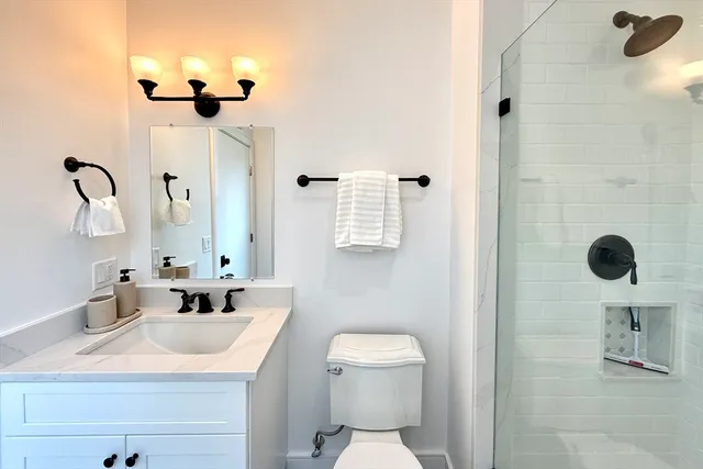 a bathroom with a sink a toilet and a mirror