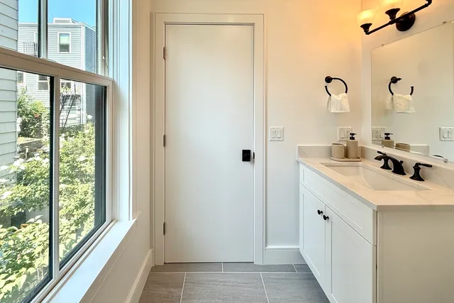 a bathroom with a double vanity sink window and mirror