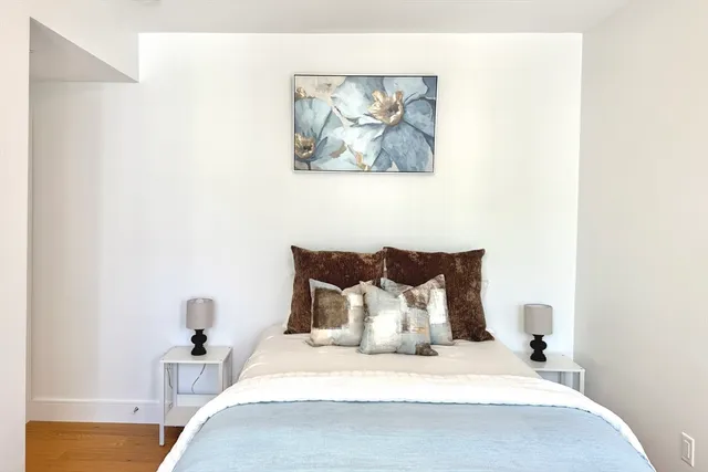 a bedroom with a bed and a painting on the wall