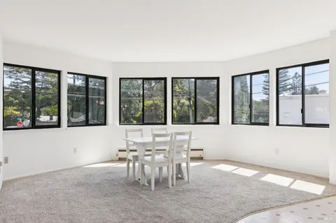 a view of a room with furniture and large windows