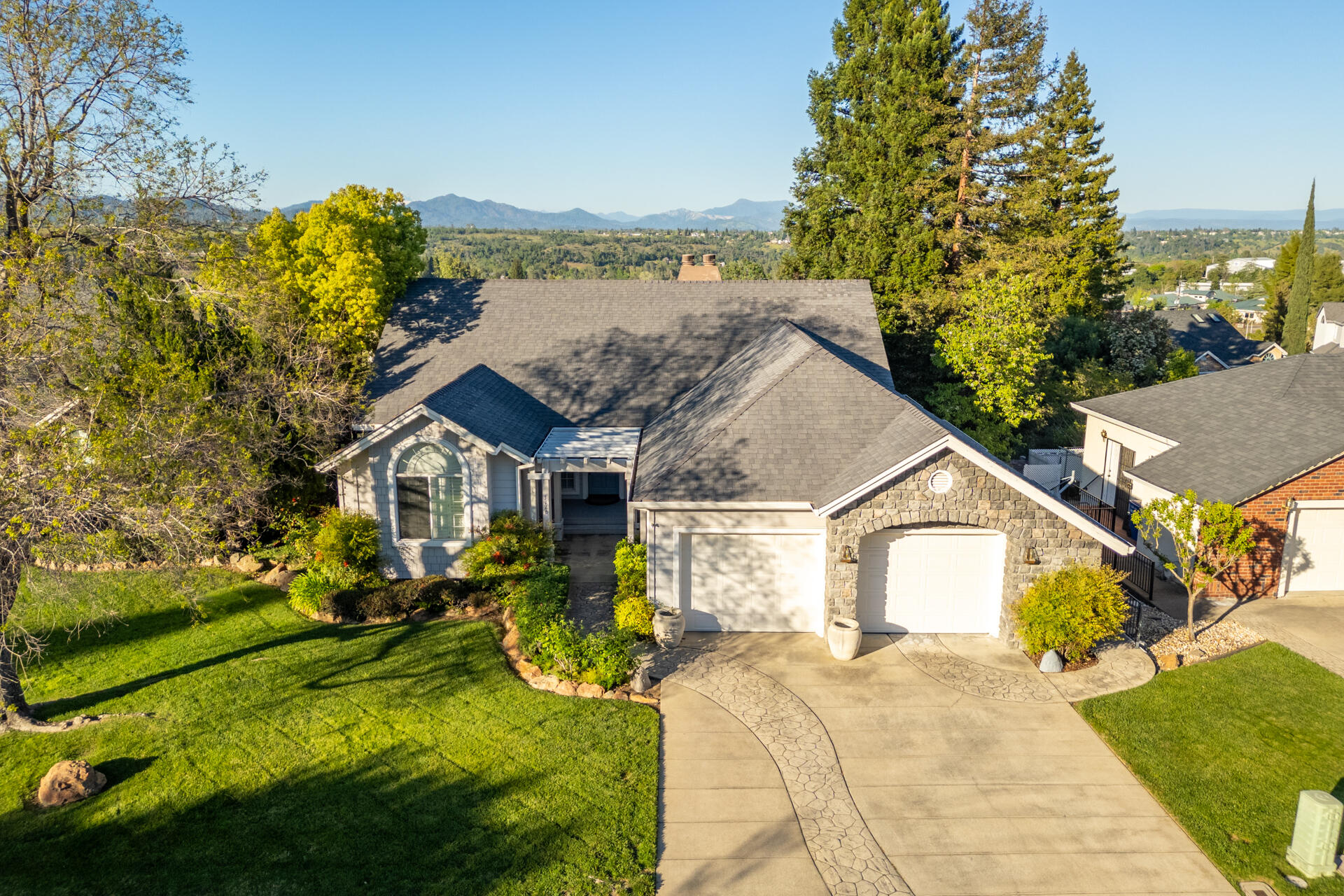 a view of a house with a big yard plants and large trees