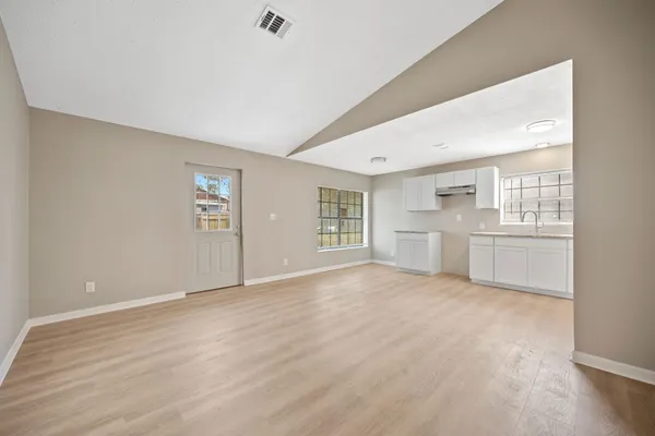 a view of a kitchen with wooden floor and a sink