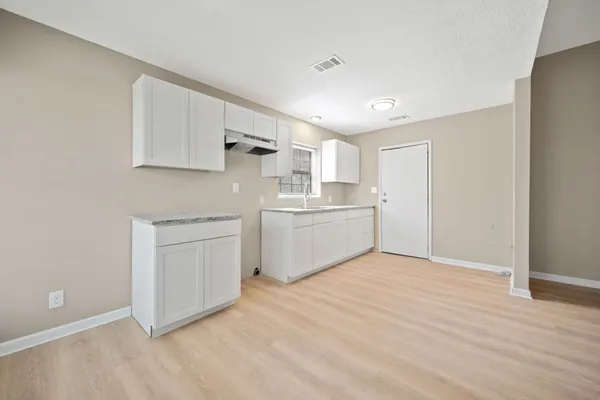 a kitchen with white cabinets and white appliances