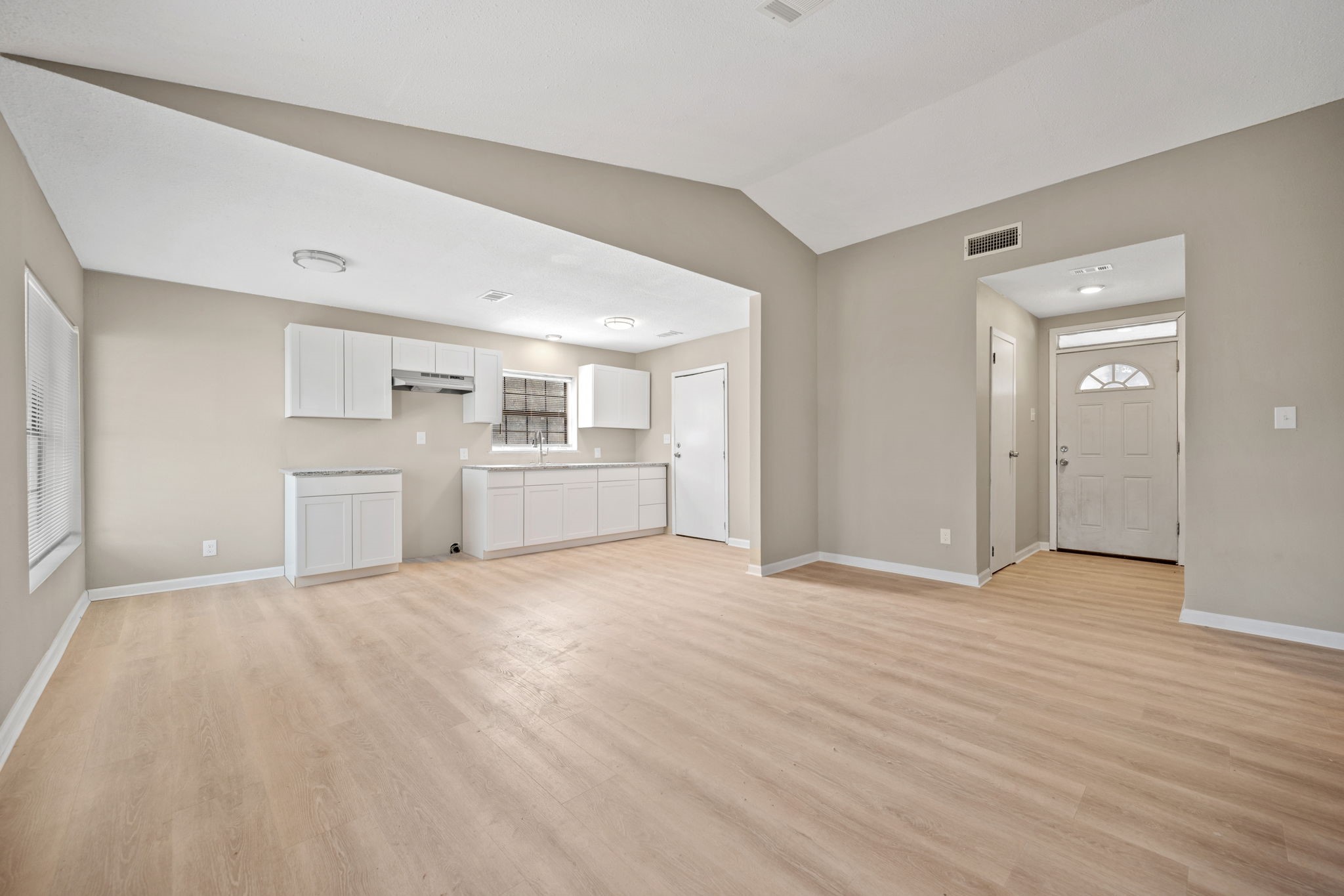 61 Beeson Avenue Shepherd, TX 77371 - Photo 8 of 14 an empty room with wooden floor kitchen view and windows