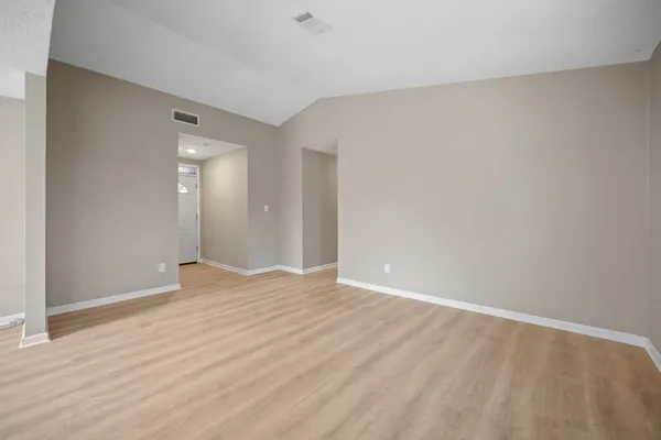 a view of an empty room with wooden floor