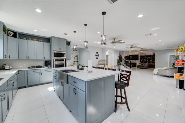 a kitchen with stainless steel appliances granite countertop a sink a stove and a refrigerator