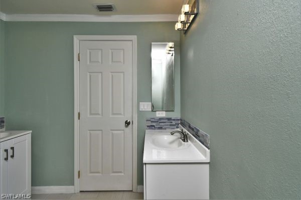8180 Liriope Loop Lehigh Acres, FL 33972 - Photo 21 of 34 a bathroom with a sink and a mirror