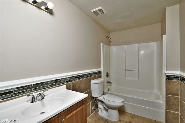 8180 Liriope Loop Lehigh Acres, FL 33972 - Photo 23 of 34 a bathroom with a sink a toilet and shower