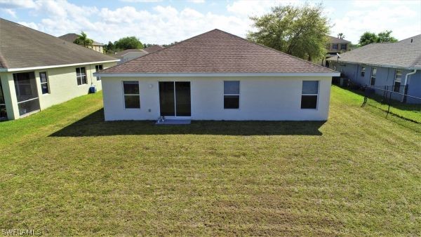 8180 Liriope Loop Lehigh Acres, FL 33972 - Photo 31 of 34 a front view of a house with a yard