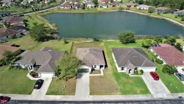 8180 Liriope Loop Lehigh Acres, FL 33972 - Photo 33 of 34 an aerial view of a house with a garden and lake view