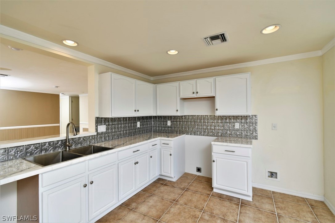 8180 Liriope Loop Lehigh Acres, FL 33972 - Photo 7 of 34 a kitchen with a sink and cabinets