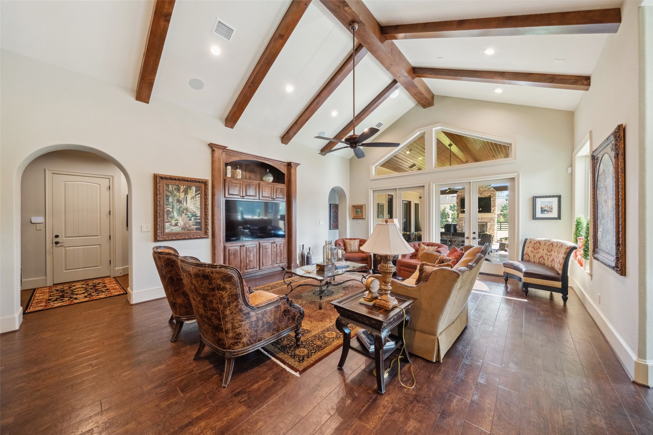 18 Rugged Lark Circle Tomball, TX 77377 - Photo 16 of 50 Family Room is light and bright with easy access to the Outdoor Paradise. Built in with hidden wiring for TV and sound system. Wood beamed ceilings and many views of the pool.