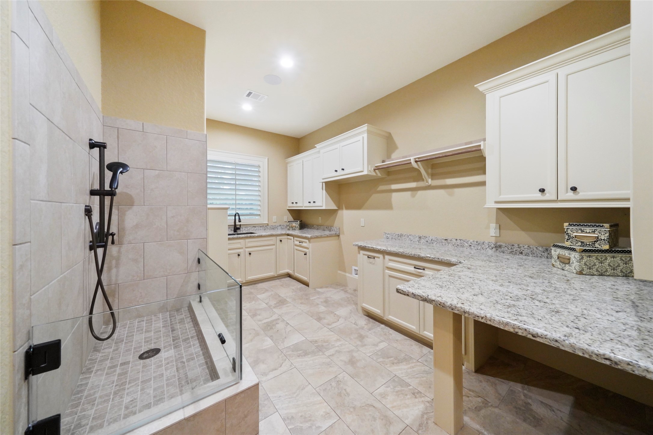 18 Rugged Lark Circle Tomball, TX 77377 - Photo 23 of 50 Utility room featuring a Dog Wash with hand held sprayer - sink - raised platform for washer & dryer, tons of storage and plug for additional refrigerator or freezer. Gift wrap station is just another added feature within this home.
