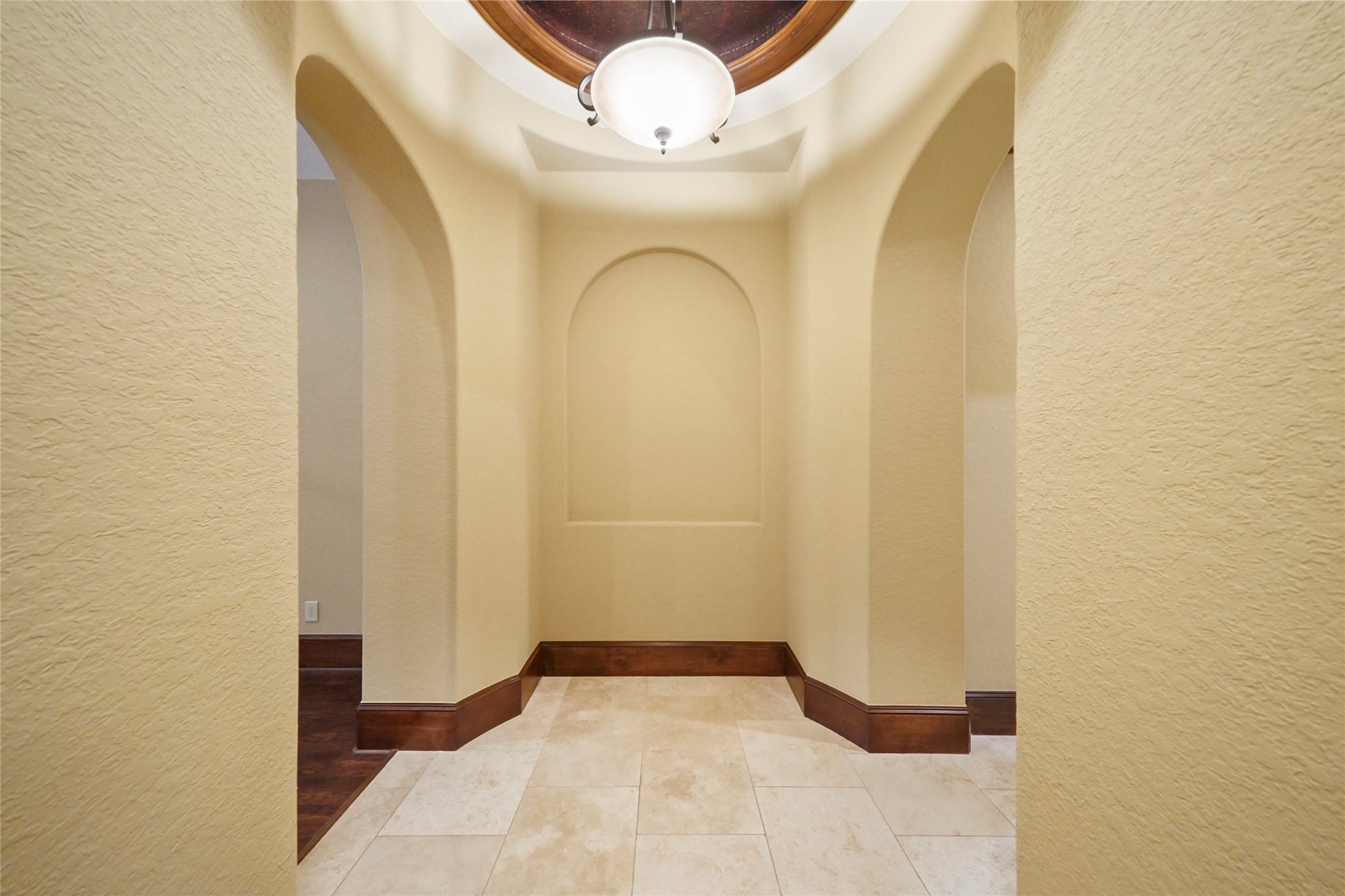 18 Rugged Lark Circle Tomball, TX 77377 - Photo 27 of 50 WIDE corridor hallway leading to Primary Private Suite. Dont forget to Look Up and see the architectural ceiling feature. Art Niche and locking door to Primary Wing. Bedroom on the left and bath/closets to the right.