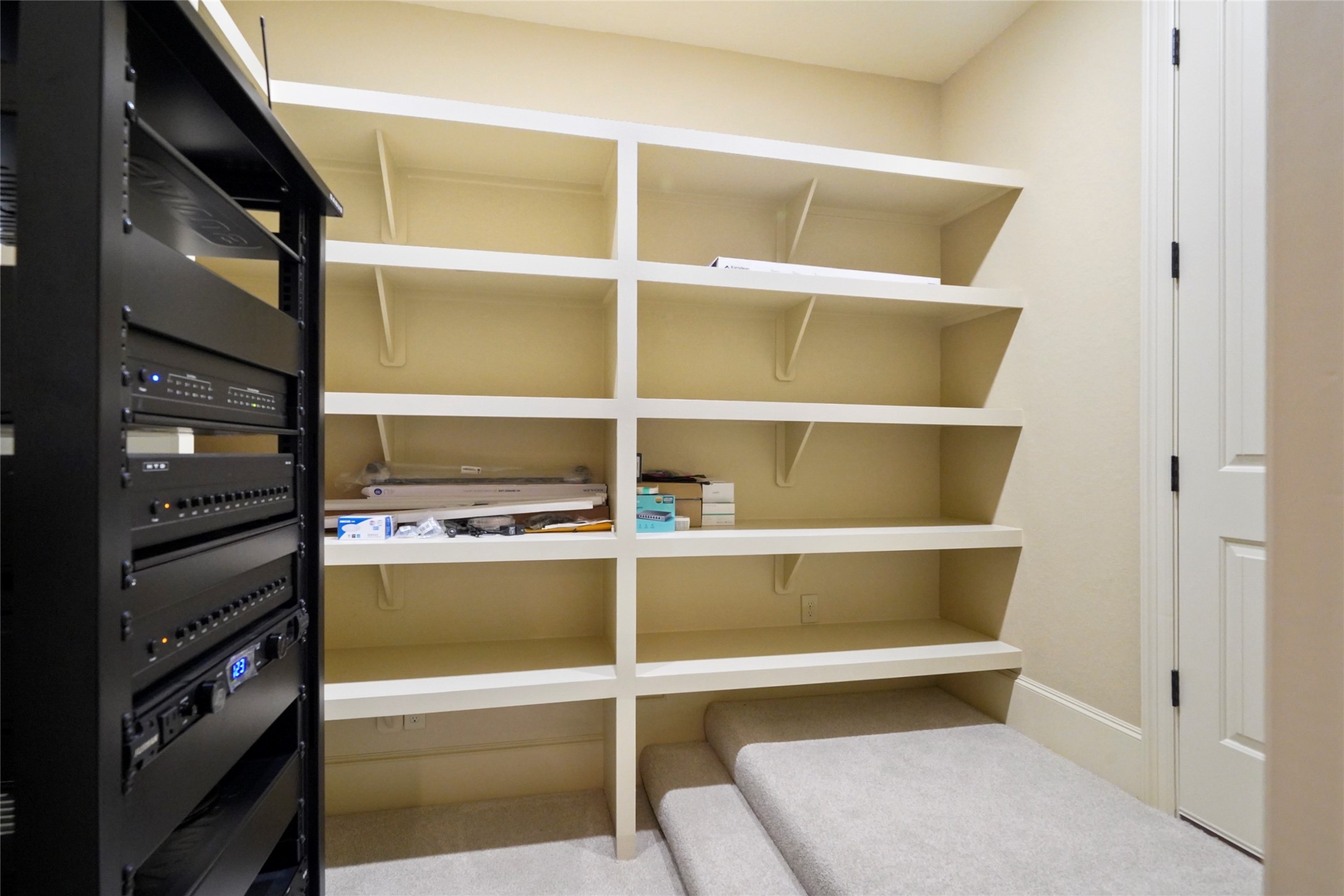 18 Rugged Lark Circle Tomball, TX 77377 - Photo 40 of 50 Upstairs Equipment closet with additional shelving. Door leads to more storage space.
