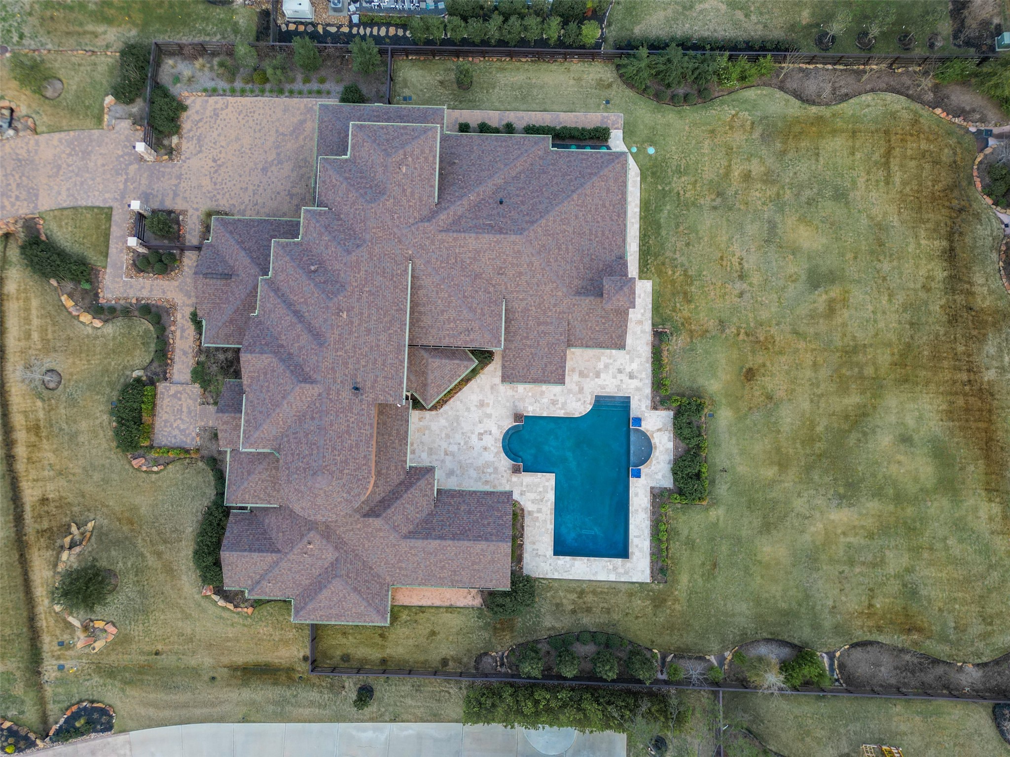 18 Rugged Lark Circle Tomball, TX 77377 - Photo 48 of 50 Aerial view of this .89 acre lot. You can see the extensive pavers on driveway and walkways. Privacy Landscaping along side and back fences. Equipment strategically placed on side of house to be hidden from street and backyard views. This photo show the massive amount of Travertine in Backyard Paradise