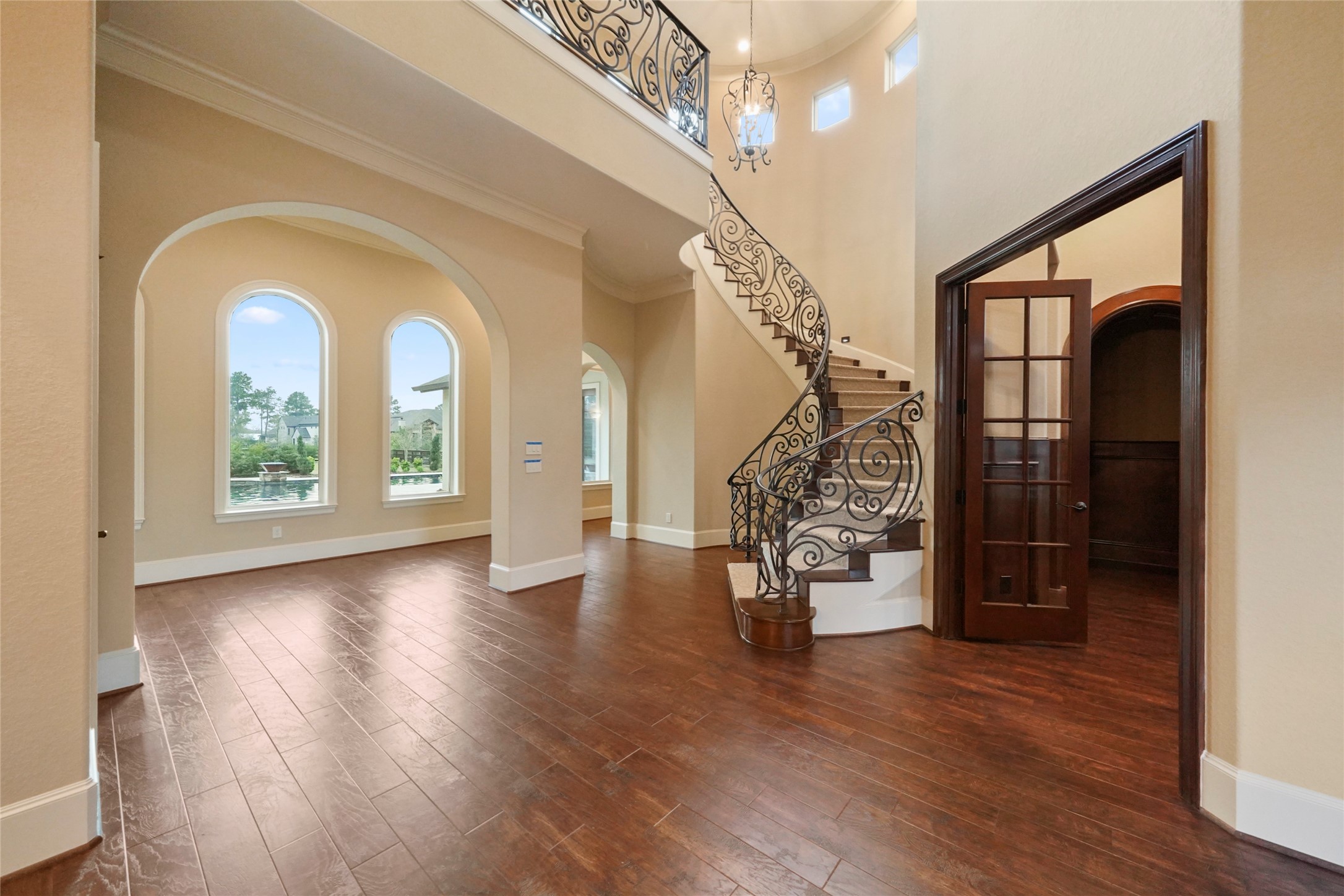 18 Rugged Lark Circle Tomball, TX 77377 - Photo 5 of 50 Wood plank flooring highlights this magnificent Entry. From the custom lighting - two story entry - Ornamental Wrought Iron sweeping staircase, to the perfectly framed arched windows beaming with natural light. Walking through the front door is like entering a resort.