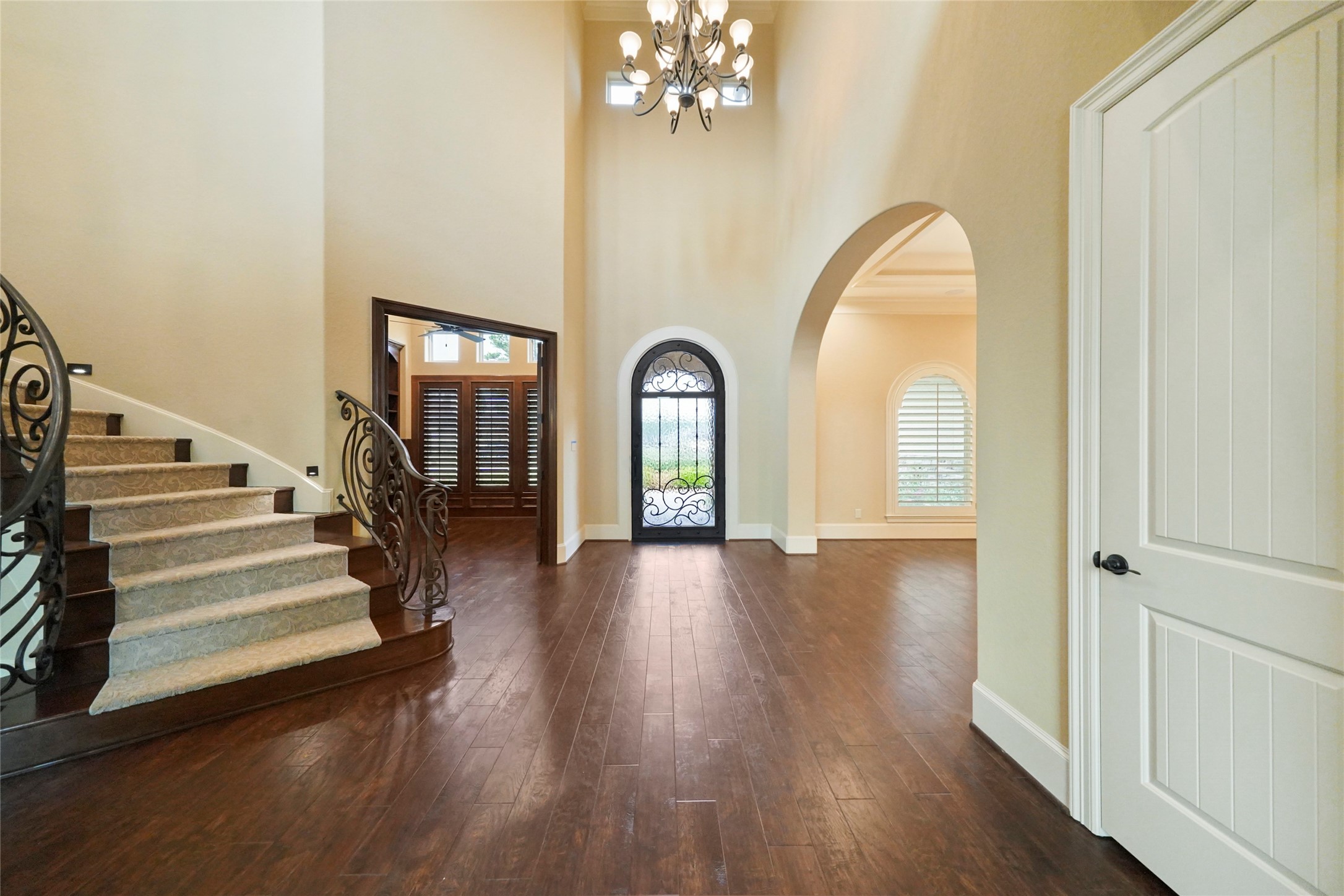18 Rugged Lark Circle Tomball, TX 77377 - Photo 6 of 50 App controlled designer lights/security/ garage/sound/ and so much more! View from the Den again highlights the staircase, arched oversized iron front door, custom lighting and beautiful durable flooring.