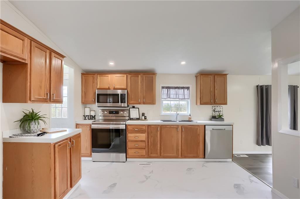 140 McCaslin Road New Castle, PA 16101 - Photo 4 of 28 a kitchen with stainless steel appliances a sink a stove a refrigerator cabinets and a window