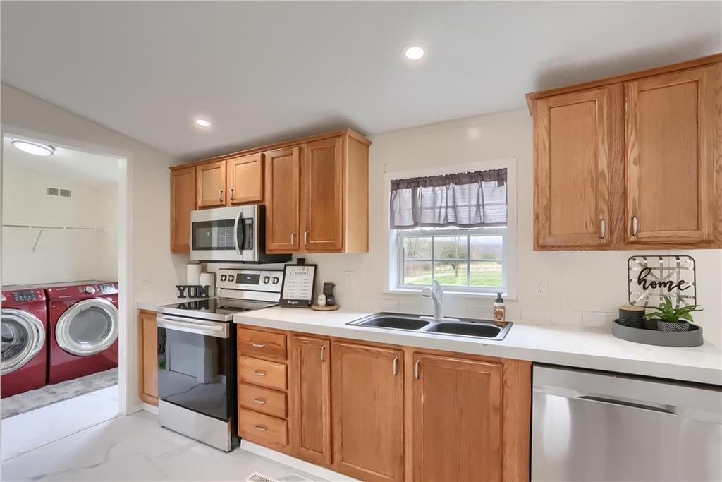 140 McCaslin Road New Castle, PA 16101 - Photo 7 of 28 a kitchen with stainless steel appliances granite countertop a sink a stove a refrigerator cabinets and a window