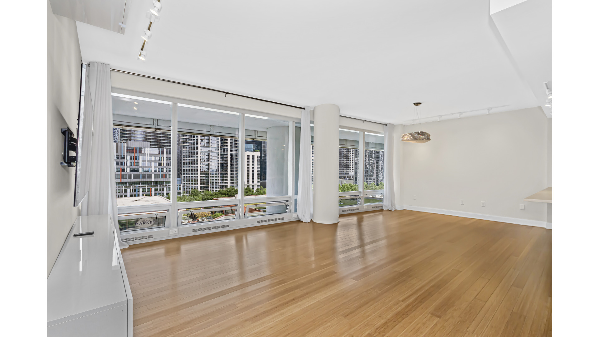 340 East Randolph Street, Unit 404 Chicago, IL 60601 - Photo 4 of 20 a view of an empty room with wooden floor and a window