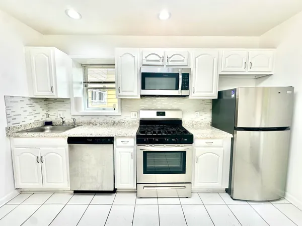 a kitchen with cabinets appliances and a sink