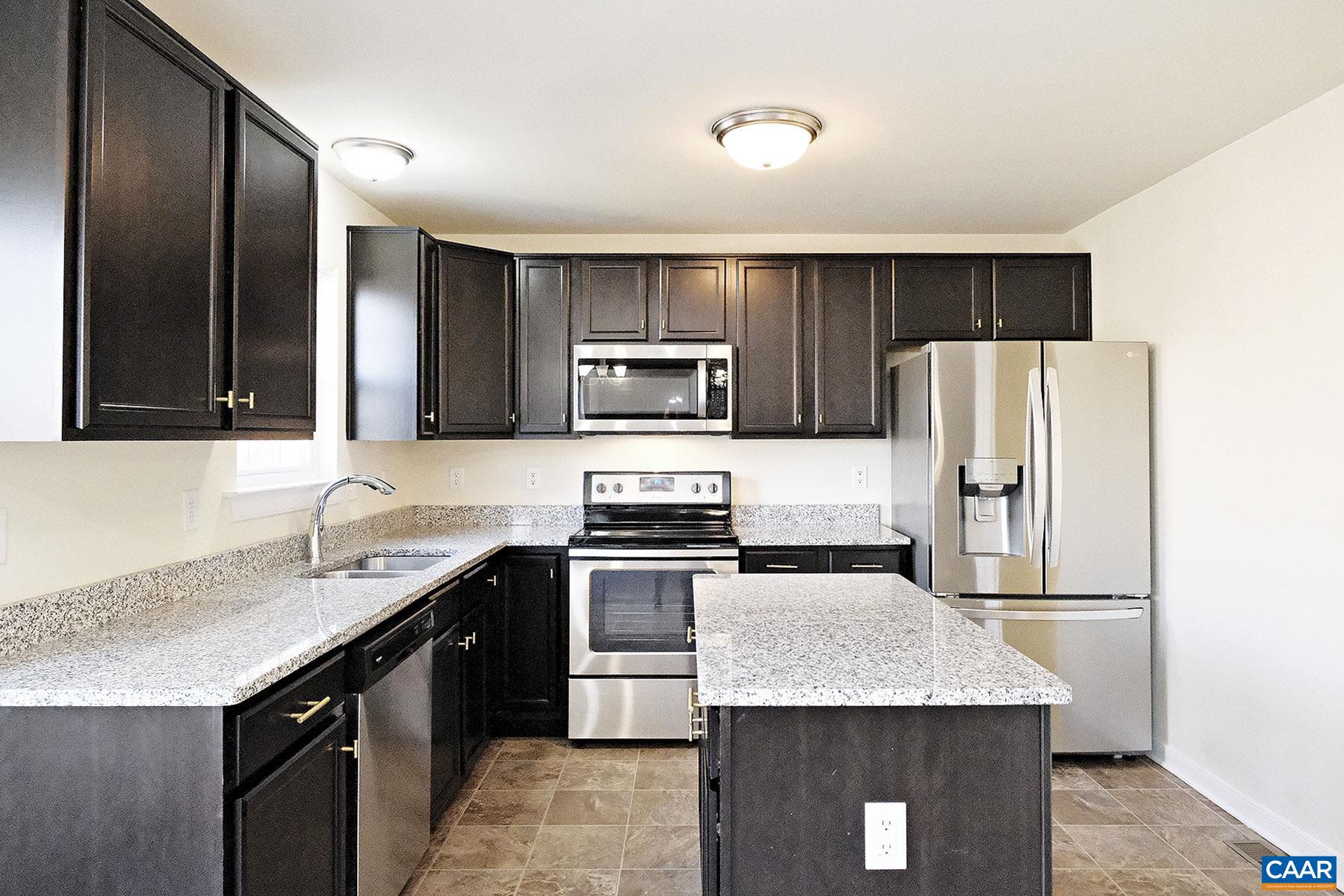 115 Reedy Creek Road Louisa, VA 23093 - Photo 5 of 17 a kitchen with kitchen island granite countertop stainless steel appliances a sink and a refrigerator