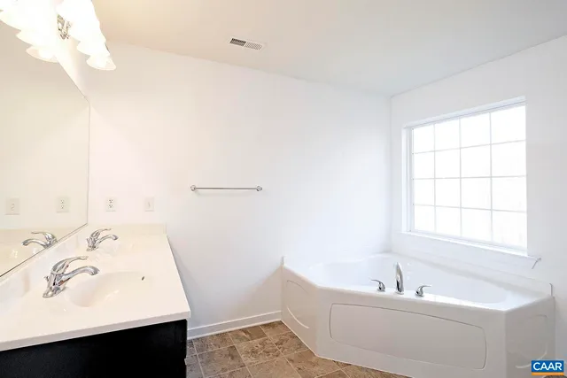 a bathroom with a sink a bathtub and a window