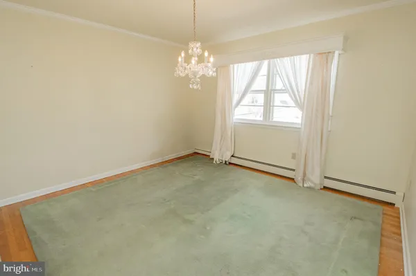 an empty room with windows and chandelier fan