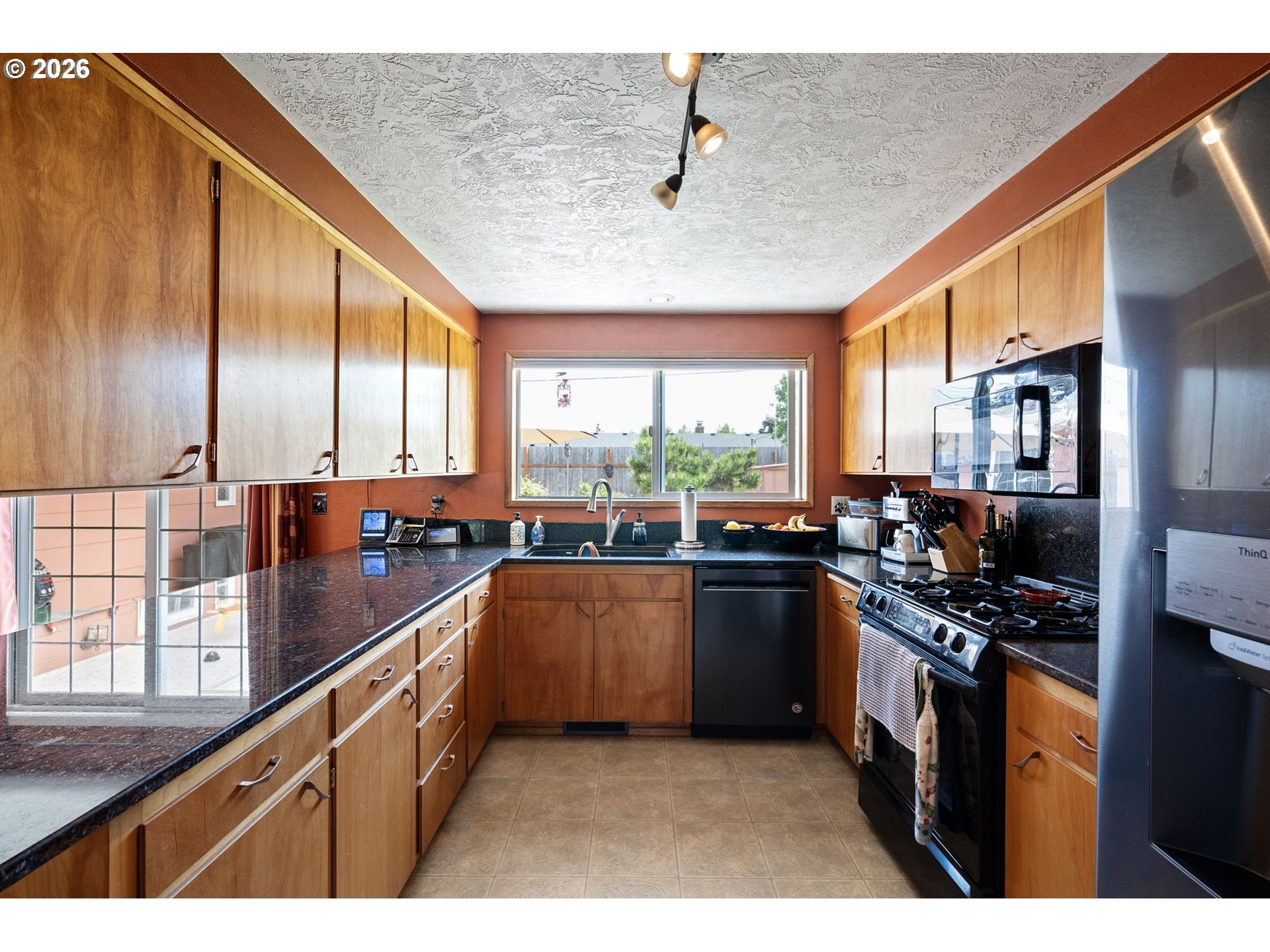 2465 17th Street Springfield, OR 97477 - Photo 15 of 47 a kitchen with stainless steel appliances kitchen island granite countertop a stove a sink dishwasher and cabinets with wooden floor