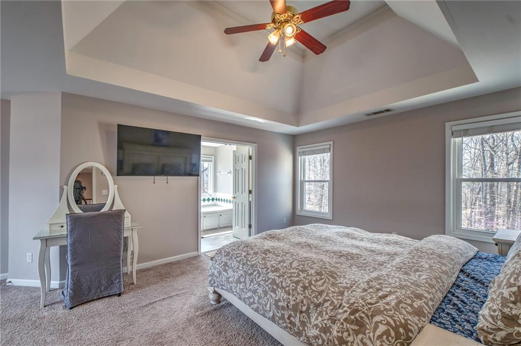 2234 Oak Falls Lane Buford, GA 30519 - Photo 11 of 23 a bedroom with a bed next to a window and a chandelier