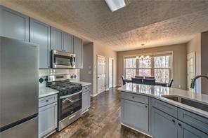 2234 Oak Falls Lane Buford, GA 30519 - Photo 6 of 23 a kitchen with stainless steel appliances granite countertop a stove a sink and a refrigerator