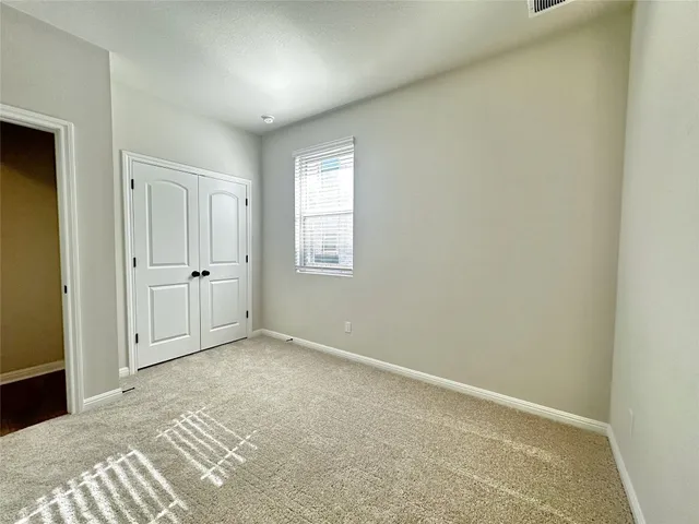 an empty room with windows and closet