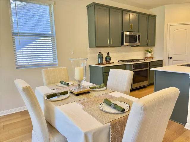 a kitchen with a table chairs stove and microwave