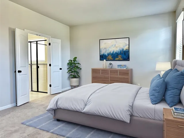 a bedroom with a large bed and a painting on the wall