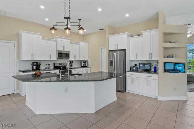 a kitchen with stainless steel appliances granite countertop a sink and a refrigerator