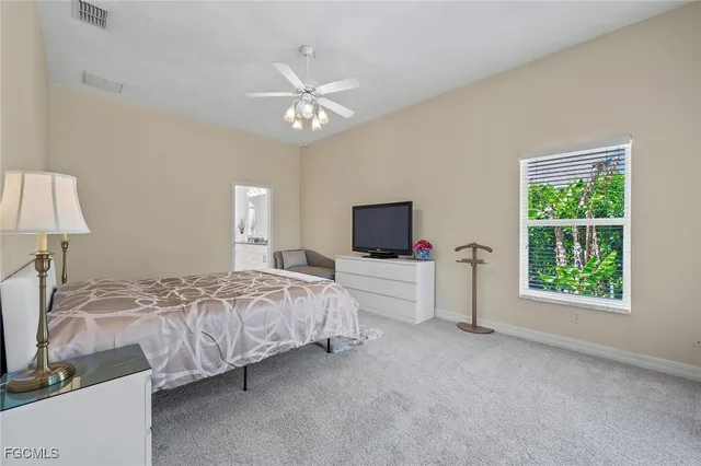 a spacious bedroom with a bed and a flat screen tv