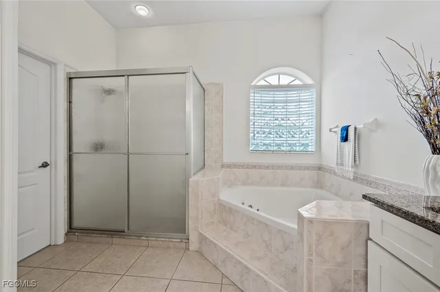 a bathroom with a granite countertop tub shower and sink