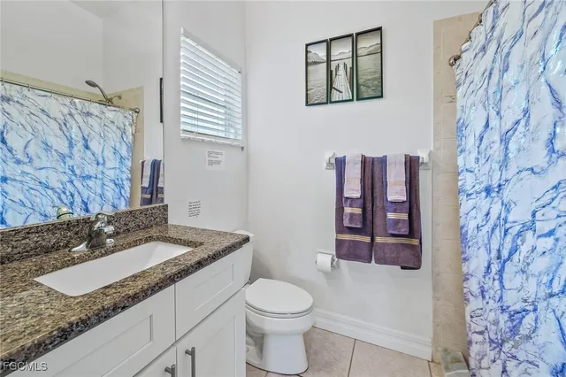 a bathroom with a granite countertop sink mirror vanity and toilet