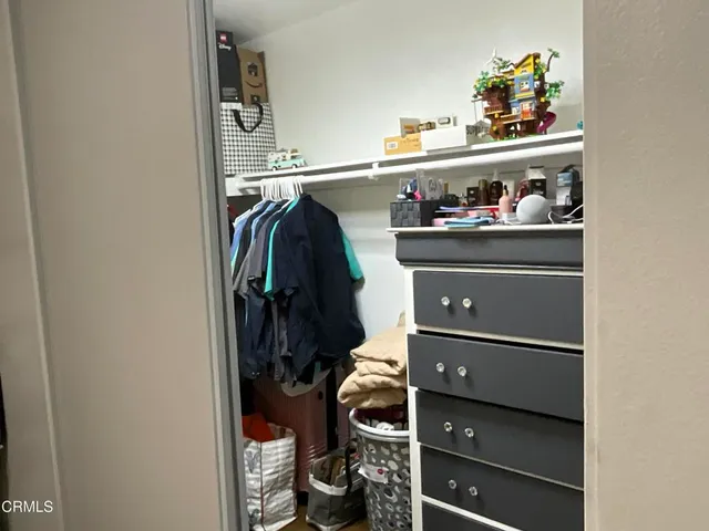 a view of walk in closet with clothes and shoes