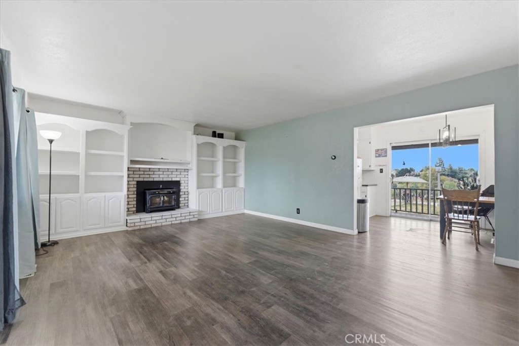 34863 Wildwood Canyon Road Yucaipa, CA 92399 - Photo 3 of 22 an empty room with wooden floor and fireplace