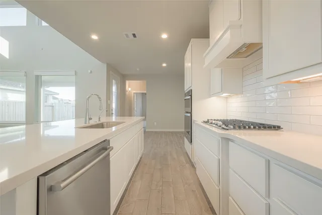 a large kitchen with stainless steel appliances granite countertop a lot of counter space and a sink