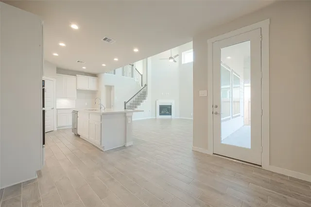 a view of a kitchen with refrigerator and white walls