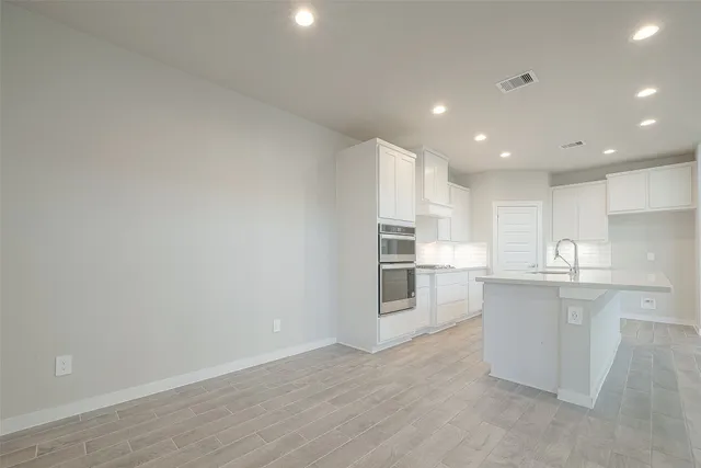 a kitchen with white cabinets and stainless steel appliances