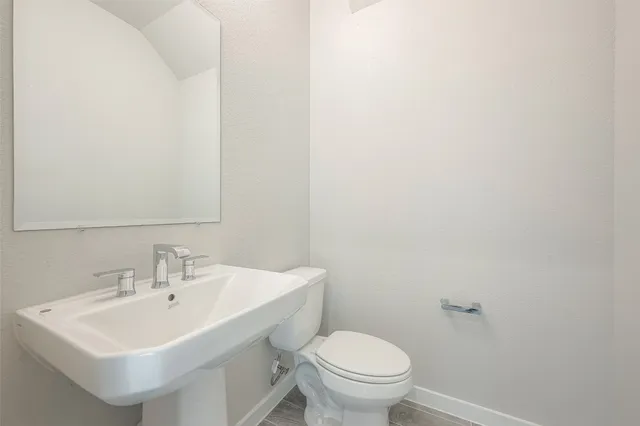 a bathroom with a sink a toilet and mirror