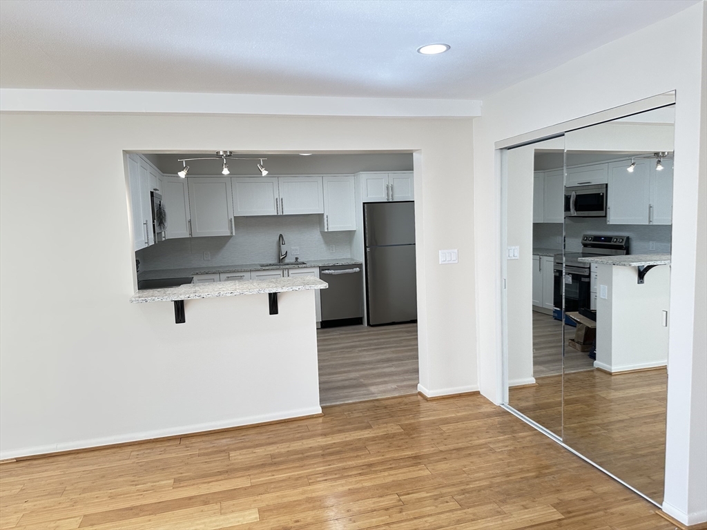 1004 Paradise Road, Unit 1K Swampscott, MA 01907 - Photo 13 of 37 a kitchen with stainless steel appliances kitchen island granite countertop a refrigerator and a sink